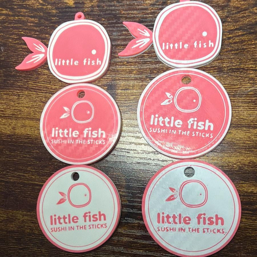 Set of 'little fish' branded round labels on a wooden surface